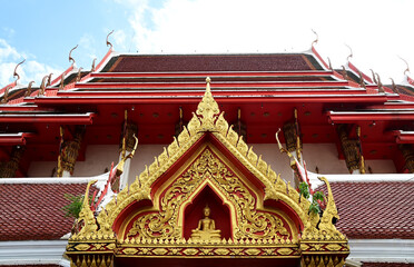 Naklejka premium BANGKOK, THAILAND - July 23, 2024: Part of the Roof of a temple in Thailand. Traditional Thai style pattern on the roof of a temple with Blue Sky Background.