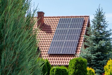 House roof with photovoltaic modules. Historic farm house with modern solar panels on roof and wall High quality photo