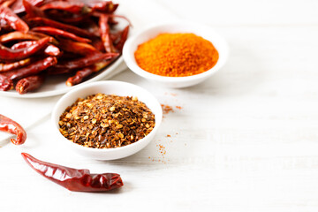 Dried red chilies on white wooden table.