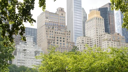 New York City Manhattan Midtown. Central park on 5th Fifth 5 avenue, USA. American landmark, urban public park in NYC, United States. Buildings architecture on 59 street thru garden trees greenery.