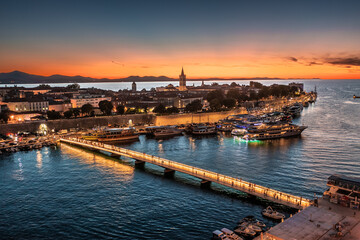 Zadar, Croatia - Aerial view of the city of Zadar at golden sunset sky with illuminated City Bridge (Gradski most), Cathedral of St. Anastasia tower and yacht marina