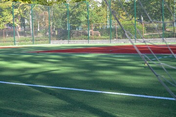 School soccer stadium. Empty soccer field behind the iron fence. High quality photo