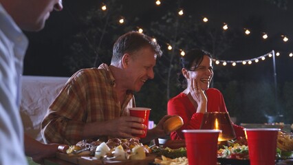Family gather for holiday celebration. Focus old mother, father and middle age son together eat dinner party. Outdoor activity for spending time with lovely relatives cross generation gap. Divergence.
