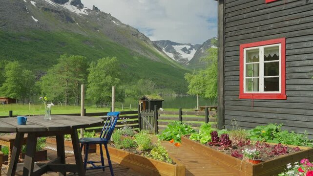 Idyllic farm scene with vegetable garden, wooden house, and mountains in Innerdalen, Norway