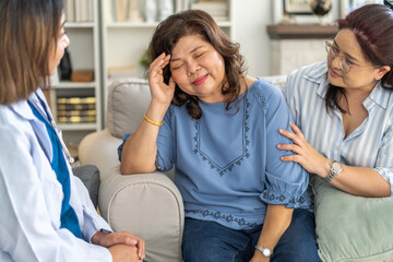 Female healthcare professional providing at home medical care to elderly woman with smile, senior patient, nursing, listens attentively to nurse, elderly care, home health services, patient at home