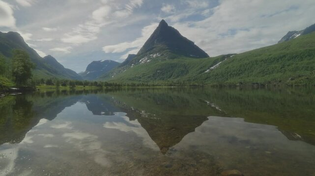 Beautiful reflection of Innerdalst&aring;rnet mountain peak on a serene lake in Innerdalen valley