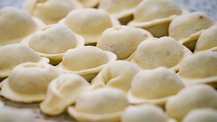 Homemade dumplings close-up. handmade dumplings on a wooden board, selective focus, tinted image, traditional Russian dish,