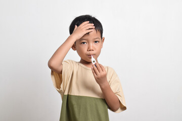 Little Asian boy is sick with thermometer in mouth and hand on forehead isolated on white background. healthcare concept.