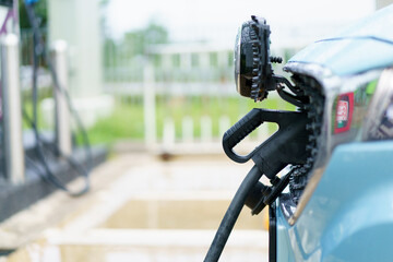 The electric car or EV is charging at public charging station.