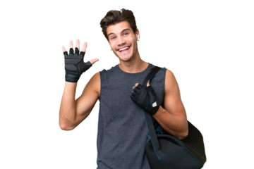 Young sport caucasian man with sport bag over over isolated background saluting with hand with happy expression