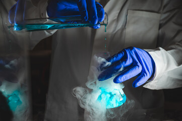 Smoky experiments with blue colour solution.  Scientist working on chemical reaction