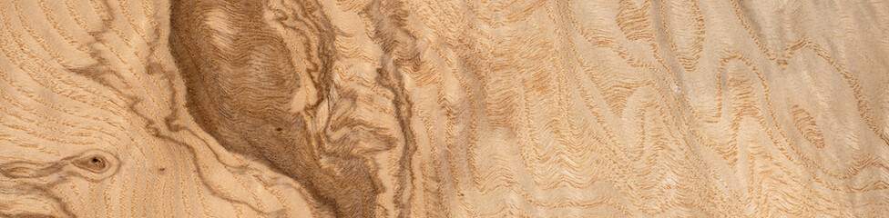Warm golden hues of olive ash root veneer with dynamic wood grain
