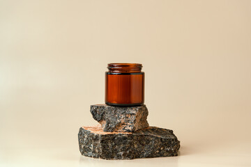 Glass Jar On Stacked Rocks Against Beige Background © fotofabrika