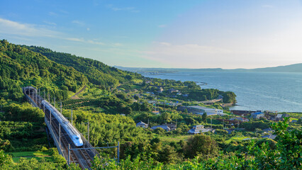 高速道路建設前の有明海の夕日を浴びて激走する九州新幹線