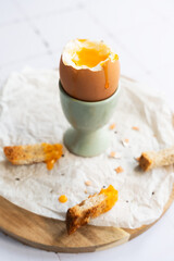 Soft boiled egg with liquid yolk on egg cup. Protein food