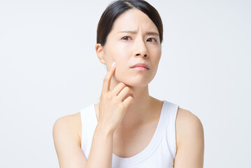 肌トラブルに悩むタンクトップ姿の女性