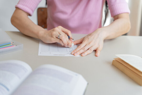 Asian girl&nbsp;student doing exam hand holding pencil writing answer in university classroom education high school or university student taking notes while preparing for exam
