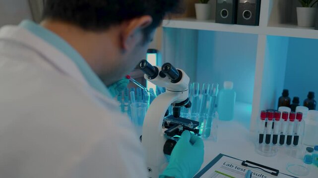 a scientist is working in the laboratory and using microscope, a chemistry is very concentration on his work, science is always in our dairy life, wearing gloves while work in the lab