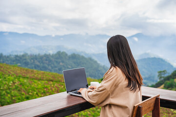 Young woman freelancer traveler working online using laptop and enjoying the beautiful nature...