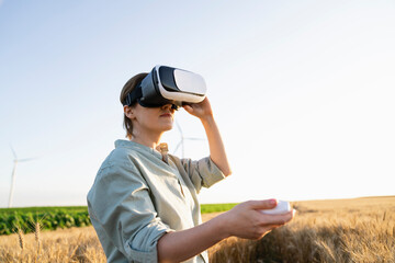 Agronomist operating virtual reality headset standing in wheat field