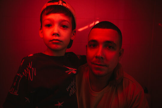 Boy with arm around father amidst red light