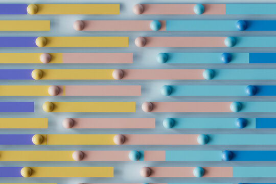 3D render of multi colored bars with spheres over blue background