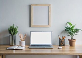 Fototapeta premium Empty modern minimalist desk with a large blank framed display, laptop, pencils, and a notebook, perfect for showcasing your creative project or design.