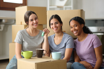 Three happy roommates showing keys moving home