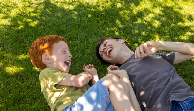 Joyful mother spending leisure time with son in garden