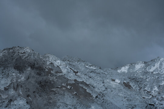 Mountains of coal against stormy clouds