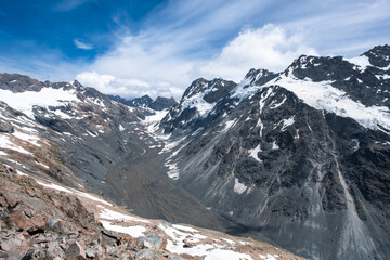 A majestic snowy mountain valley with rugged terrain and dramatic skies, capturing the raw beauty and pristine nature of the highlands.