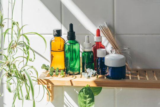 Bathroom essentials kept on wooden shelf mounted on tiled wall