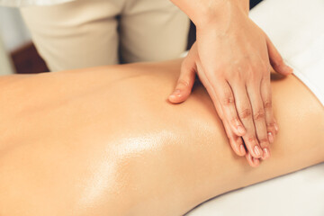 Closeup woman customer enjoying relaxing anti-stress spa massage and pampering with beauty skin recreation leisure in day light ambient salon spa at luxury resort or hotel. Quiescent