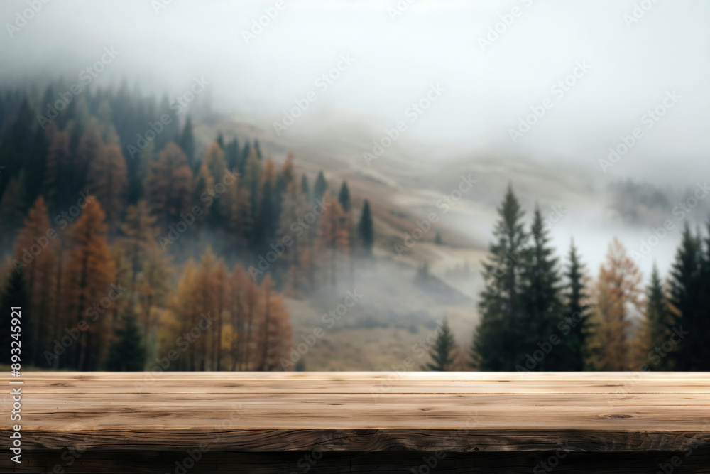 Poster Empty wooden tabletop is set against a blurred backdrop of a misty forest landscape in autumn