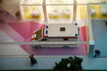 Ambulances outside a hospital entrance in a miniature city scene. Model landscape photography for...
