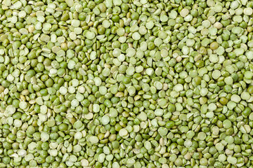 Uncooked, split, green peas background. Dry peas grains. Top view