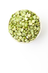Uncooked, green peas in bowl on white background. Top view. Space for a text