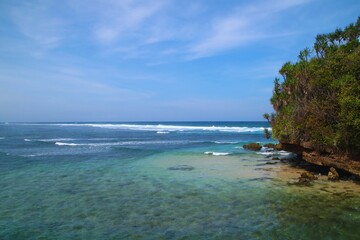 Fototapeta premium Bale Kambang Beach in East Java with a beautiful beach view on a sunny day with a blue sky horizon and sea foam waves