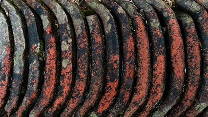 Piles of old and mossy roof tiles used for house restoration