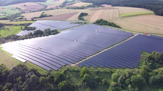 Drohne fliegt &uuml;ber gro&szlig;e Solaranlage in der Natur, Energiewende, Luftaufnahme