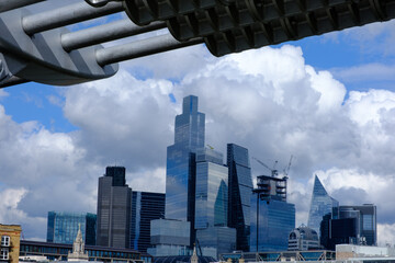 The City of London busines district framed by the Millennium footbridge set against a dramatic stormy sky, London, UK