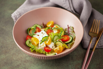 Easy greek salad of fresh cucumber, tomato, arugula,  feta cheese  with olive oil. Healthy food.