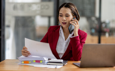 Cheerful business Asian woman accounting making telephone call share good news about project working in office workplace, business finance concept.	