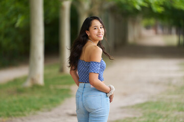 Fototapeta premium A woman in a blue shirt and blue jeans is smiling and posing for a picture