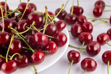 Ripe red cherries on plate isolated on white background