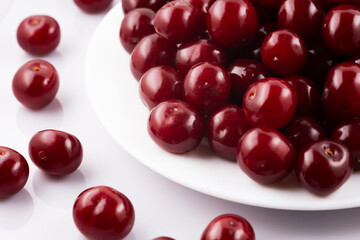 Ripe red cherries on plate isolated on white background