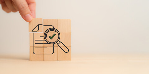 Audit, verifying financial concept. Wooden blocks forming an image of a document with a magnifying...