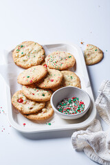 Christmas cookies with white chocolate and green-red sprinkles, white background.