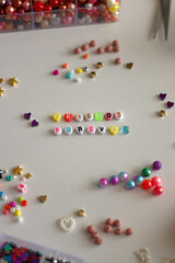 Friends forever written with colorful beads. Jewelry making supplies on the table. Making friendship bracelets concept. Selective focus.