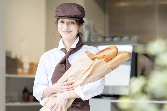 フランスパンを抱えている制服姿の女性